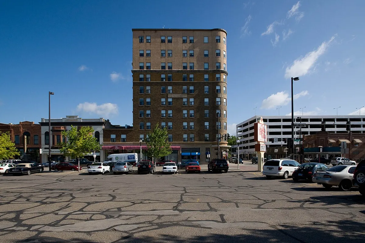 Downtown Bismarck with the McKenzie Building behind a weathered, cracked parking lot