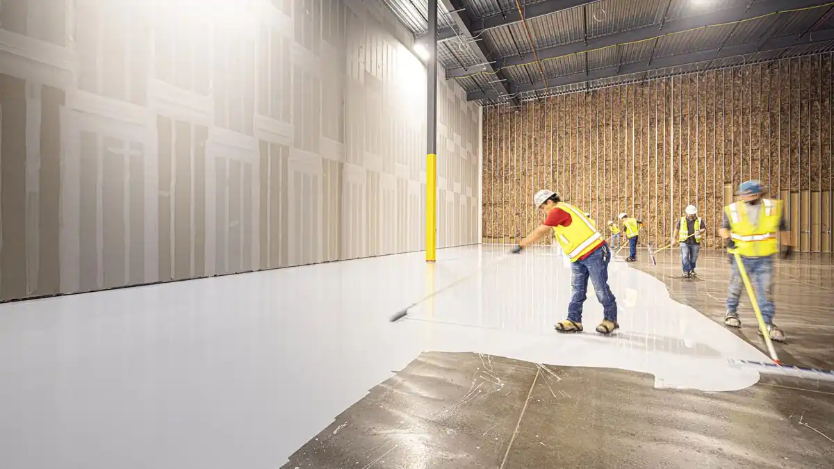 Coating crew installing an epoxy floor over a prepared concrete slab in Bismarck ND